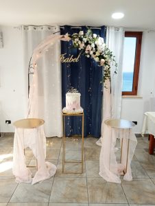 Alt text= Arco floreale con torta scenografica Emozioni Floreali Villa San GIovanni