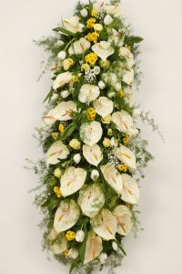 Alt="Copricassa anthurium bianco e tulipani e margheritine gialle-Emozioni Floreali di Giusy Surace"